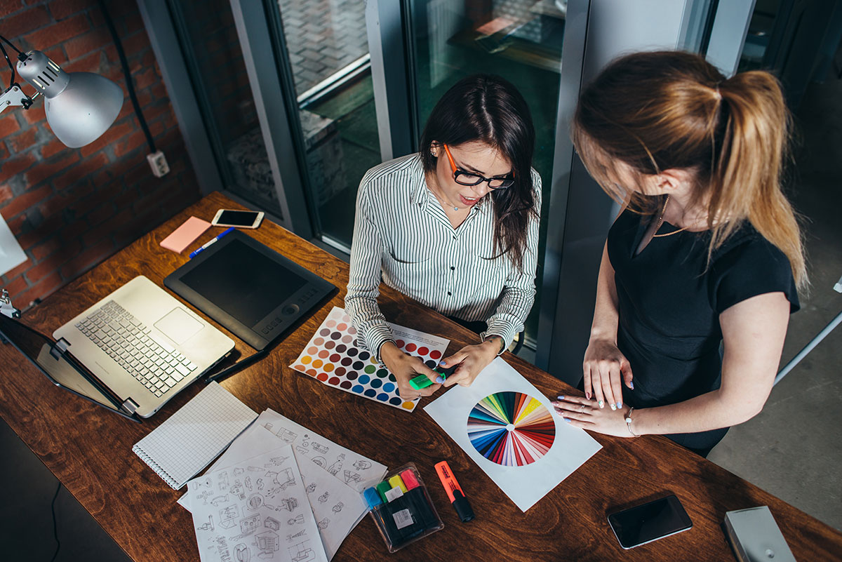 Female designer helps female homeowner pick a color pallet for her new design project to complement her new furniture. 