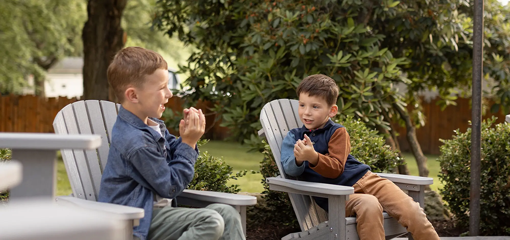 Two boys outside on Amish furniture chairs